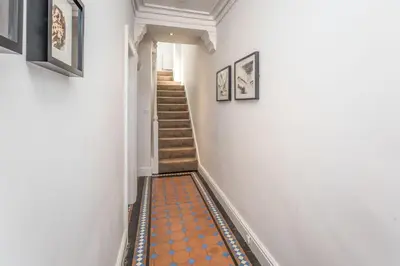 a hallway with a staircase with orange tiles on the floor at 9 The Townhouse in Keswick