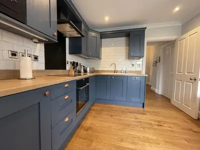 a kitchen with blue cabinets and a wooden floor at Park View in Keswick