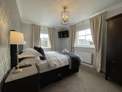 a bedroom with a bed and a lamp and windows at Park View in Keswick