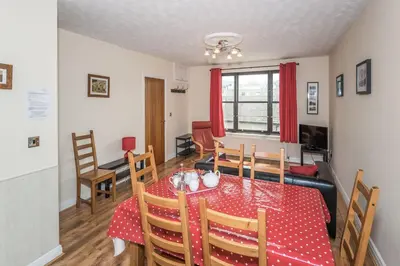 a dining room with a red table and chairs at Alban Rise in Keswick