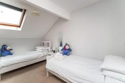 two beds with dolls sitting on them in a room at Alban Rise in Keswick