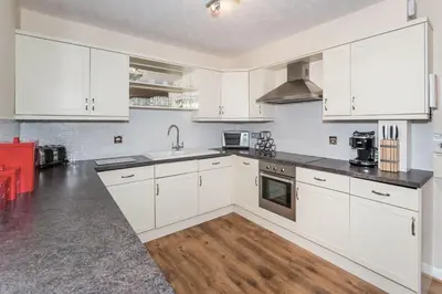 a white kitchen with white cabinets and a counter top at Alban Rise in Keswick