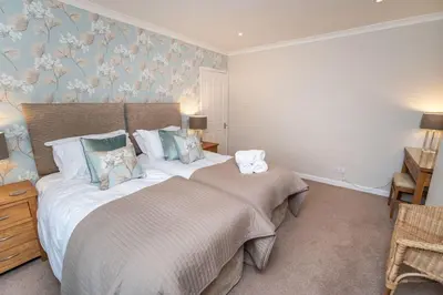 a bedroom with a bed and a wall with flowers at Appletree in Portinscale