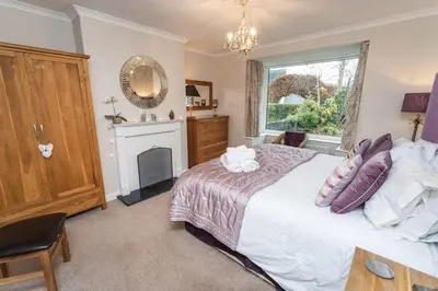 a bedroom with a bed and a fireplace and a window at Appletree in Portinscale