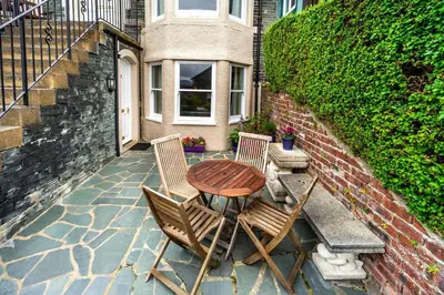 a wooden table and two chairs on a patio at The Ridgeway in Keswick