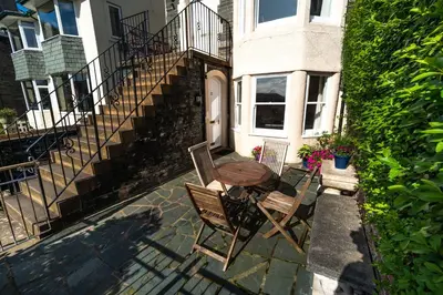 a patio with two chairs and a table in front of a house at The Ridgeway in Keswick