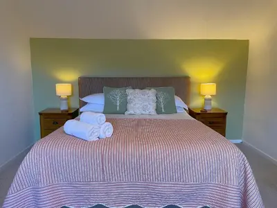 a bedroom with a large bed with towels on it at Roslin in Portinscale