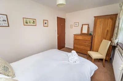 a bedroom with a bed with two towels on it at Quaver Cottage in Keswick