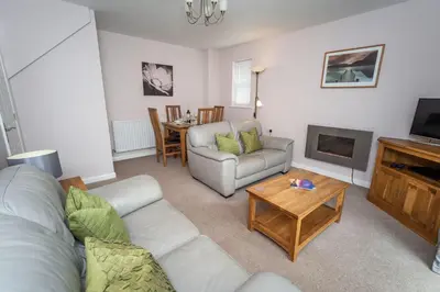 a living room with a couch and a table at Elm Cottage in Keswick