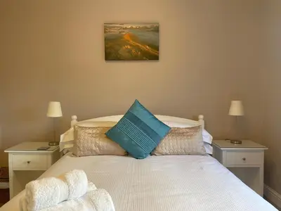 a bedroom with a white bed with two night stands at Coledale in Keswick