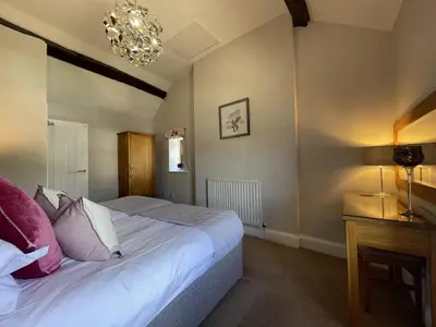a bedroom with a bed and a chandelier at Bridge House in Keswick