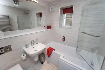 a bathroom with a sink and a toilet and a shower at Bridge House Apartment 1 in Keswick