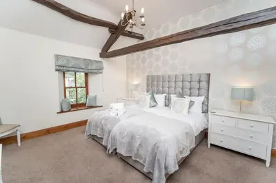 a bedroom with a large white bed and a window at Bridge House Apartment 3 in Keswick