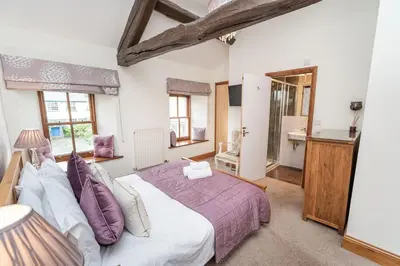 a bedroom with a large bed and a bathroom at Bridge House Apartment 3 in Keswick