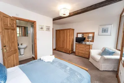 a bedroom with a bed and a couch and a television at Bridge House Apartment 2 in Keswick