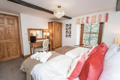 a bedroom with two beds and a desk in it at Bridge House Apartment 2 in Keswick
