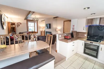 a kitchen and living room with a table and a dining room at Bridge House Apartment 2 in Keswick
