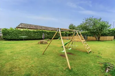 a wooden swing set in a yard at Bridge Mews in Keswick