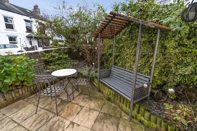 a gazebo with a bench and a table and chairs at Byways in Keswick
