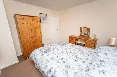 a bedroom with a bed and a dresser and a mirror at Blencathra in Keswick