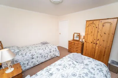 a bedroom with two beds and a dresser at Blencathra in Keswick