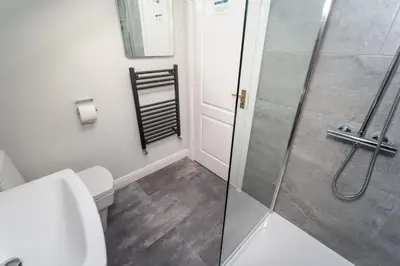 a bathroom with a toilet and a glass shower at Alison's View in Keswick