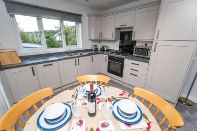 a kitchen with a table and chairs in a kitchen at Alison's View in Keswick