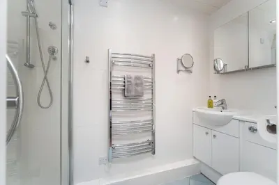 a white bathroom with a shower and a sink at Maiden Moor in Keswick