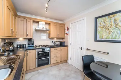 a kitchen with wooden cabinets and a table and a sink at Maiden Moor in Keswick