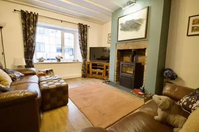 a living room with a couch and a fireplace at Millside Cottage in Braithwaite