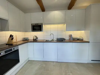 a kitchen with white cabinets and a sink at Lake View Cottage in Braithwaite