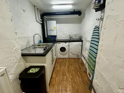 a small kitchen with a sink and a washing machine at Daisy Cottage in Keswick