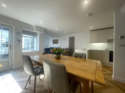 a kitchen and dining room with a wooden table and chairs at Daisy Cottage in Keswick