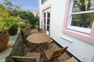 a patio with a table and chairs and a window at Greta Bank in Keswick
