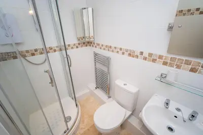 a bathroom with a toilet and a sink and a shower at Greta Bank in Keswick