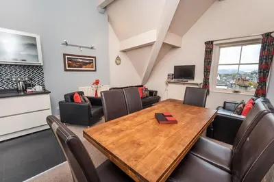 a living room with a wooden table and chairs at Crandy Nook in Keswick