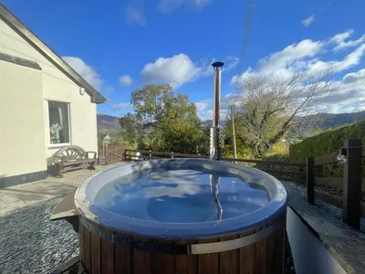 a jacuzzi tub on the patio of a house at Rock Lynn in Braithwaite