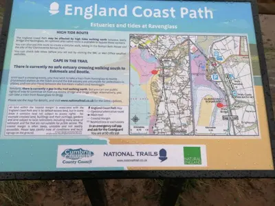 a sign for the entrance to the island coast path at Ravenglass Log Cabin in Ravenglass
