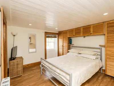 a bedroom with a bed and a flat screen tv at 2 Burnside Place in Kirkcudbright