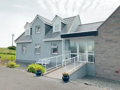 a gray house with a white porch at Float bay view in Stranraer