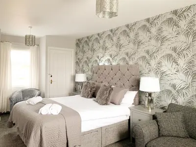 a bedroom with a large bed and a chair at Float bay view in Stranraer