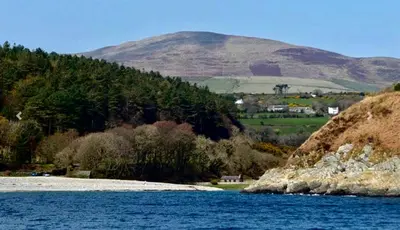 a body of water with a mountain in the background at The Glen Mona Hotel in Maughold