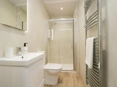 a white bathroom with a toilet and a shower at Shields in Keswick
