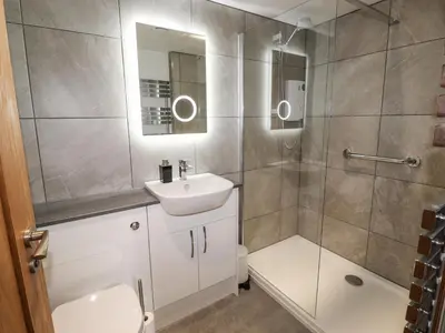 a bathroom with a shower and a sink and a toilet at Norton in Keswick