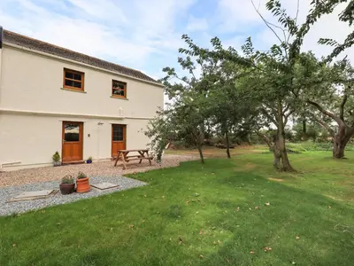 a house with a picnic table in a yard at Bramblewood Cottage in Crookdake