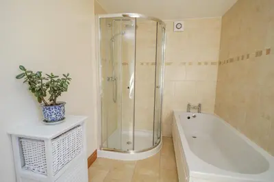 a bathroom with a shower and a bath tub at Bramblewood Cottage in Crookdake