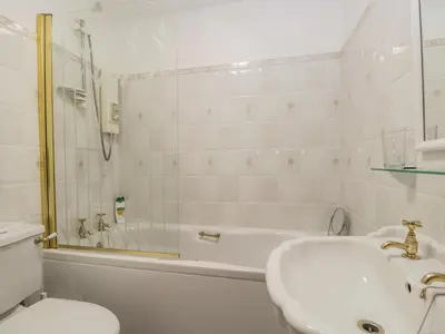 a bathroom with a tub and a sink and a toilet at Swaledale Watch Garden Annexe in Wigton