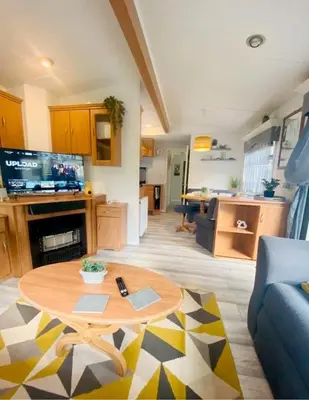 a living room with a table and a living room at Unique Caravan with Outdoor Space in Ballantrae
