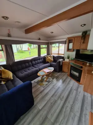 a living room with a couch and a tv at Unique Caravan with Outdoor Space in Ballantrae