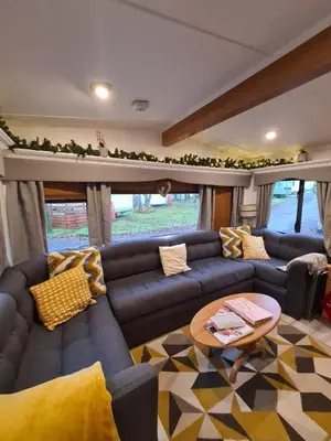 a living room with blue couches and a table at Unique Caravan with Outdoor Space in Ballantrae